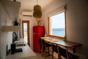 a small kitchen with a red refrigerator and a table at Divino Caldera in Akrotiri