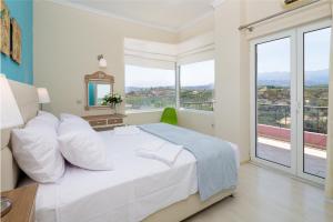 a bedroom with a bed and a large window at Villa Anatoli in Stalos
