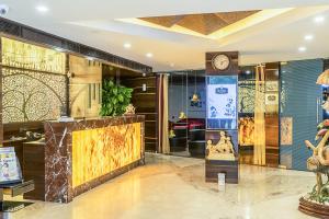 a lobby with a clock on the wall at Super Inn Armoise Hotel in Ahmedabad