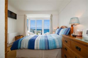 a bedroom with a bed, a desk, and a window at Seaview in Looe