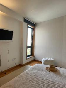 a bedroom with a bed and a flat screen tv at Mindelo apart in front of the best beach of North Portugal in Mindelo +35 photos