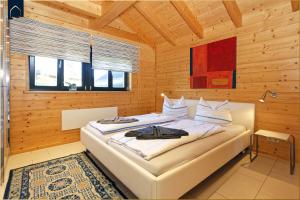 a bedroom with a bed in a wooden room at Ferienhaus Villa Riesling in Zempin