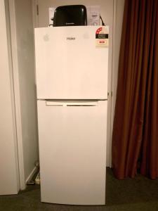 a white refrigerator in a corner of a room at Cosy Sunny Bedroom Close to Airport in Christchurch