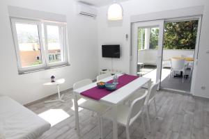 a living room with a table and chairs and a dining room at Apartment Villa Franci Pag with heating and open all year in Pag