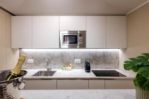 eine Küche mit Spüle und Mikrowelle in der Unterkunft NEW-Venice Suite San Marco 397 in Venedig + 17 Fotos