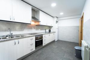 a kitchen with white cabinets and a sink at Holiday home Splendid Park Güell in Barcelona