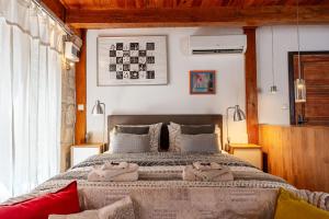 a bedroom with a large bed with two towels on it at St Roko - Cozy Stone Studio in Old Town Korčula in Korčula