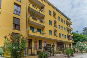 a yellow building with windows and balconies at Casa Raffaella Comfort e smart working vicino M3 e bus in Milan