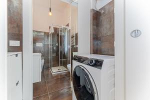 a bathroom with a washing machine and a shower at Casa Raffaella Comfort e smart working vicino M3 e bus in Milan