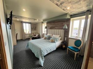 a bedroom with a bed and a blue chair at Chambres côté mer du bouquet in Cosqueville