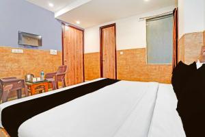 a bedroom with a bed and a table and chairs at Hotel O Tilak Nagar Near Pacific Mall in New Delhi