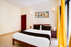 a bedroom with a large bed and a window at Townhouse Miramar View Point in Goa