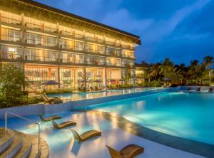 a hotel with a swimming pool in front of a building at Swiss-Belresort Belitung in Tanjungbinga
