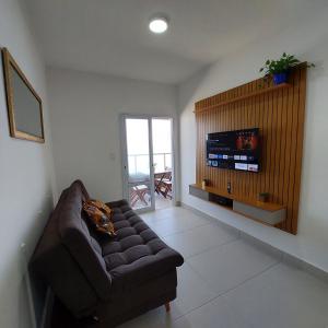 a living room with a couch and a flat screen tv at Apartamento Frente para o Mar em Praia Grande - Vista Incrível in Praia Grande