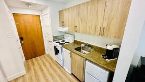 a small kitchen with wooden cabinets and a sink at Swimming Pool Spa - Condo Mont Tremblant 2 in Mont-Tremblant