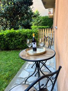 a table with two glasses and a bottle of wine at Rosa Bianca apartment - Free Parking in the historic center of Alba - Langhe in Alba