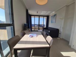uma sala de jantar com uma mesa, cadeiras e um sofá em Gemelos 26-Fincas Benidorm em Benidorm