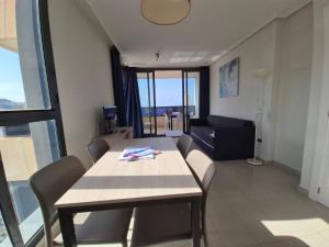 uma sala de estar com uma mesa, cadeiras e um sofá em Gemelos 26-Fincas Benidorm em Benidorm