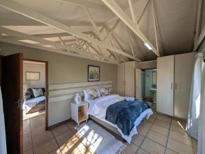 a bedroom with a large bed in a room at Oude Post Guesthouse and Cottage - The Old Postmaster's House in Lydenburg