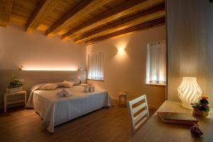 a bedroom with a bed and a table and a lamp at Enoturismo Le Rampe in Vittorio Veneto