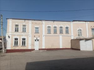 duży ceglany budynek z białymi drzwiami w obiekcie Historic house w Samarkandzie