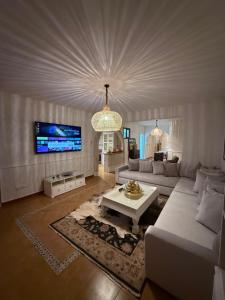a living room with a white couch and a tv at Casa Hugo in Chefchaouen
