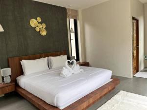a bedroom with a large white bed with a white swan on it at Pontakorn Villa 1 in Ko Phangan