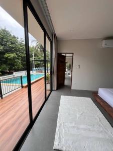 a bedroom with a view of a pool and a bed at Pontakorn Villa 1 in Ko Phangan +1 photo