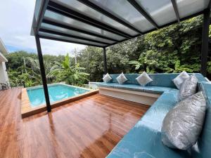 a patio with a blue couch and a swimming pool at Pontakorn Villa 1 in Ko Phangan
