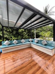 a blue couch under awning on a patio at Pontakorn Villa 1 in Ko Phangan