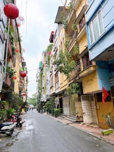 an empty street in an asian city with buildings at Homestay Nhacuabu in Hanoi