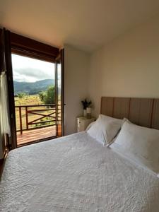 a bedroom with a bed and a large window at El refugio de Liébana in Ojedo +22 photos