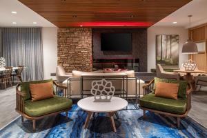 a lobby with chairs and a table and a tv at Fairfield by Marriott Inn & Suites Winters Davis in Winters