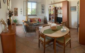 a living room with a table and chairs and a couch at Villa Kore in Fontane Bianche