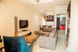 a living room with a couch and a tv at Chalis Apartment in Uyo