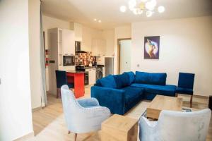 a living room with a blue couch and a table at Chalis Apartment in Uyo