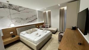 a hotel room with a bed and a tv at Memai Suites in Ksamil +31 photos