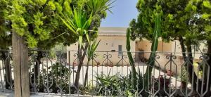 a fence with plants in front of a building at Alabianca in Villa Vela