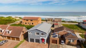 eine Luftaufnahme eines Hauses und des Ozeans in der Unterkunft Jolie Beach Apartment in Wilderness