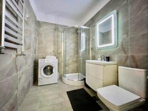 a bathroom with a toilet and a washing machine at Allezzi Resort Mamaia Nord D 13 in Mamaia +47 photos