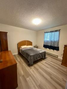 a bedroom with a bed and a wooden floor at Beautiful home near City centre! in Kitimat