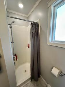 a bathroom with a shower with a shower curtain at Beautiful home near City centre! in Kitimat +1 photo