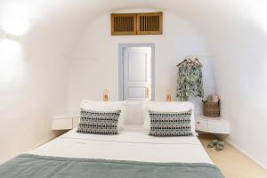 una camera con un letto e due sedie bianche di El Verano Sunset a Imerovigli Altre 57 foto