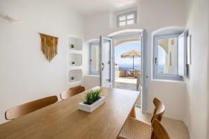una sala da pranzo con tavolo e sedie in legno di El Verano Sunset a Imerovigli