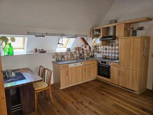 a kitchen with wooden cabinets and a table and a counter at Rebenglück in Rohrendorf bei Krems