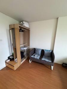 a living room with a couch and a book shelf at Condo located 5 minutes away from Suvarnabhumi Airport by taxi for cooking, short-term rental, and long-term rental in Sathani Lat Krabang