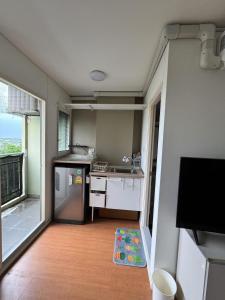 a small kitchen with a sink and a refrigerator at Condo located 5 minutes away from Suvarnabhumi Airport by taxi for cooking, short-term rental, and long-term rental in Sathani Lat Krabang