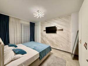 a bedroom with a bed and a tv on a wall at Allezzi Resort Mamaia Nord D 13 in Mamaia