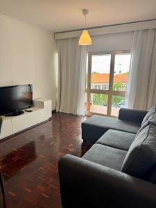 a living room with a couch and a flat screen tv at Ohana Funchal in Funchal