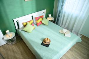 a bed with pillows and a hat on it at Summer Place in Perea